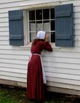 Girl peeks through Thomas House Window